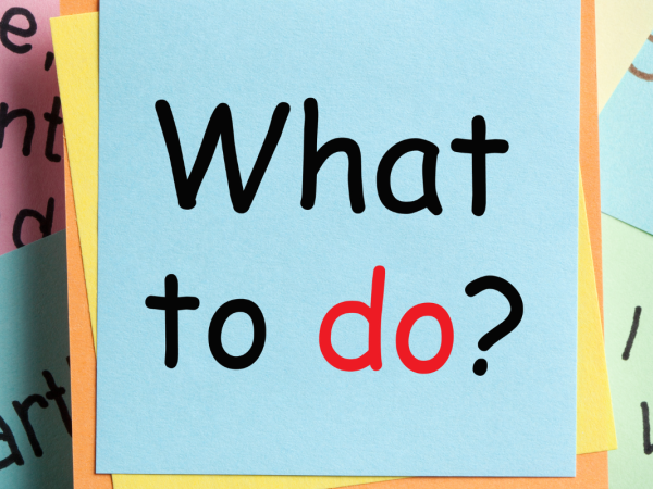 sticky notes with various writing on them, the front one saying 'WHAT TO DO?'. 