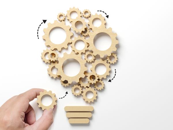 wooden cogs interlinked in the shape of a plant. 