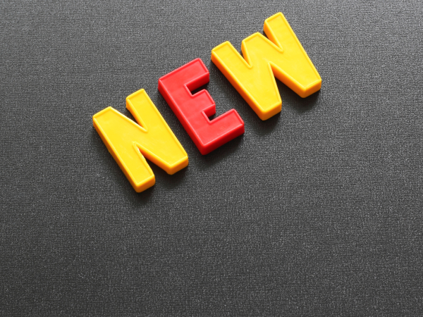 Grey background with plastic letters spelling the word 'NEW' 