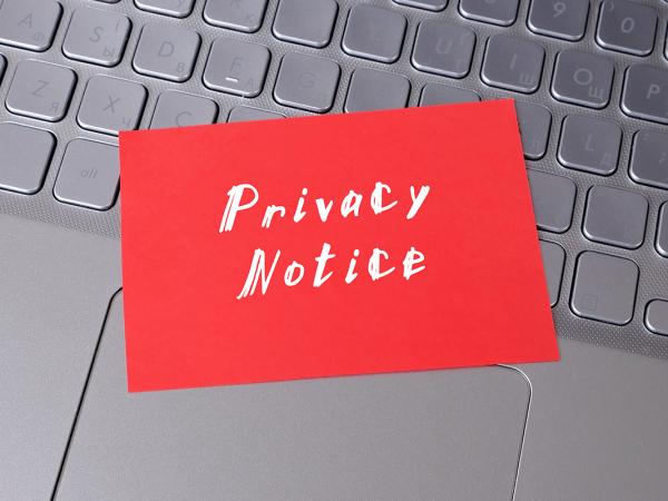 A keyboard with a red sticky note attached, the note reads 'PRIVACY NOTICE'.