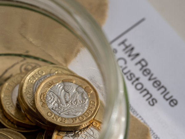 A letter from HMRC along with a glass jar of coins. A letter from HMRC along with a glass jar of coins.