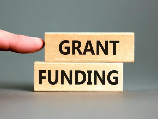 2 blocks of wood each with a word printed on it, together they read 'GRANT FUNDING'. 2 blocks of wood each with a word printed on it, together they read 'GRANT FUNDING'.