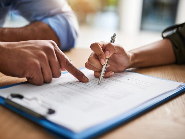 2 people filling out a form together.