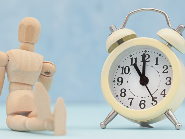 A figurine of a person sat next to a clock