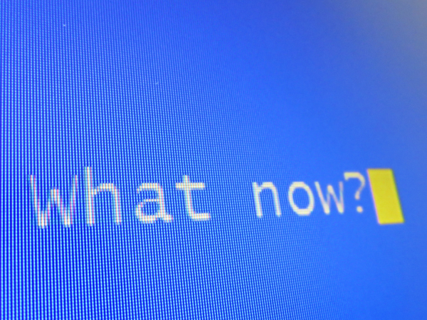 A blue computer screen with the words 'WHAT NOW?' typed in white text. A blue computer screen with the words 'WHAT NOW?' typed in white text.