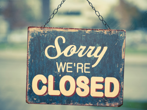 A sign hanging on a door that reads 'SORRY WE'RE CLOSED'. A sign hanging on a door that reads 'SORRY WE'RE CLOSED'.