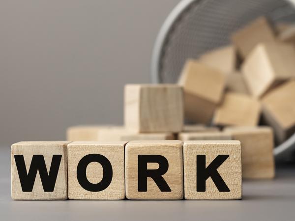 Wooden blocks with letters on, the 4 blocks in the centre spell out the word 'WORK'. 