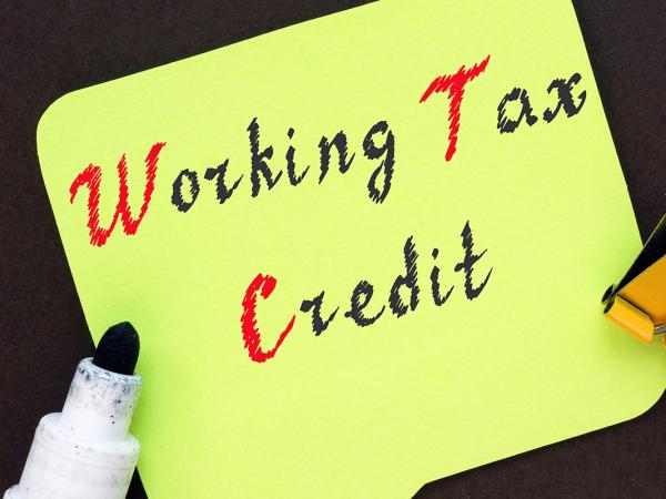 A yellow piece of paper with the words 'WORKING TAX CREDIT' written on it with black and red ink.