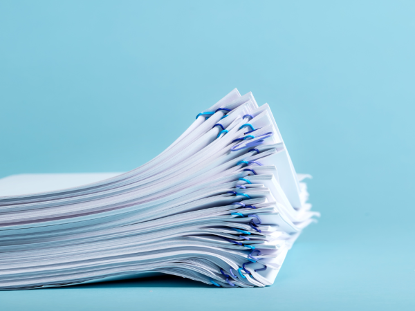 a bunch of papers clipped together against a blue background. a bunch of papers clipped together against a blue background.