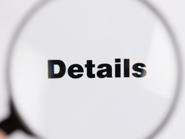 A magnifying glass hovering over the word 'DETAILS'