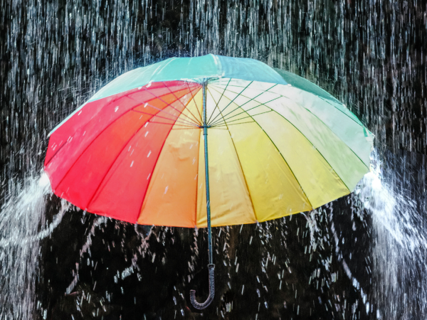 A colourful umbrella with a downpour of water A colourful umbrella with a downpour of water