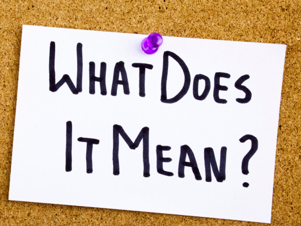 A pin board with a sheet of paper pinned to it, the paper reads 'WHAT DOES IT MEAN?'