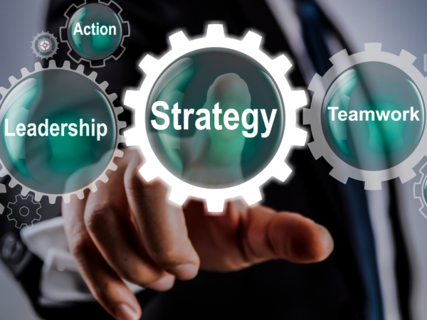 Translucent cogs each with words on them 'STRATEGY', 'LEADERSHIP', 'TEAMWORK', 'INNOVATION', 'ACTION', 'PLANNING'.