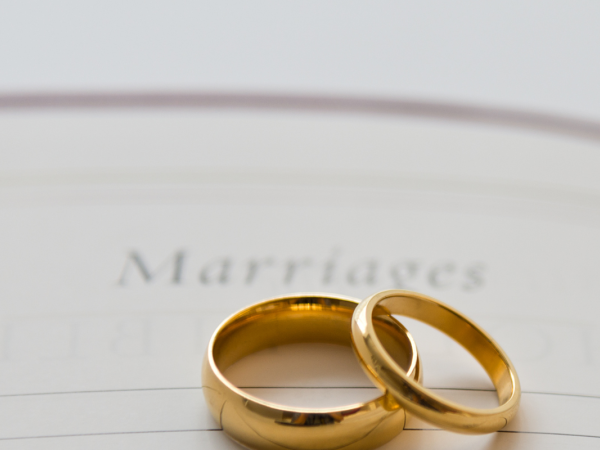 2 wedding bands sat on top of a paper with the word 'Marriages' written at the top.