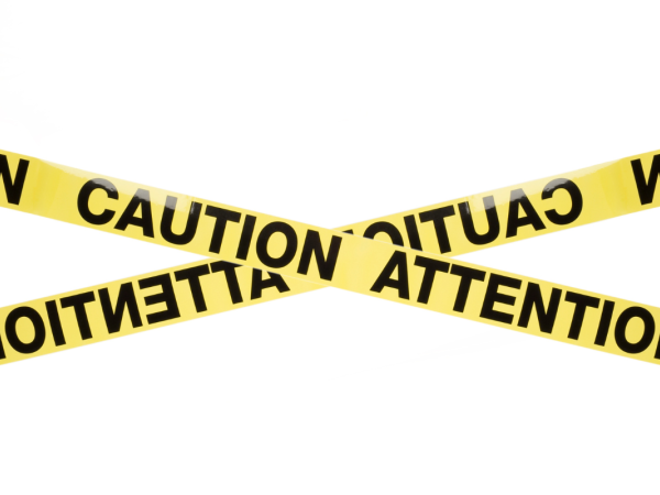 Yellow tape with the words 'CAUTION' and 'ATTENTION' in black capitals 