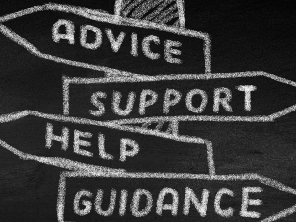 A chalkboard with a drawing of a street sign there are 4 signs that read 'ADVICE', 'SUPPORT', 'HELP', 'GUIDANCE'