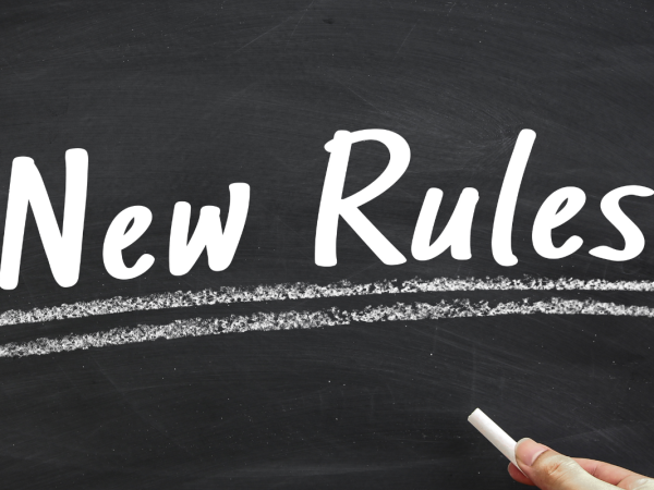 words written on a chalkboard in white chalk, the words read 'NEW RULES!'