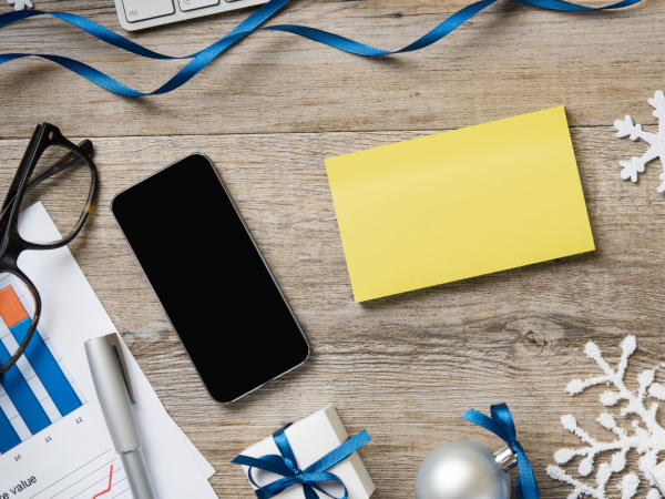 A desk with a pair of glasses, a mobile phone and various Christmas decorations. A desk with a pair of glasses, a mobile phone and various Christmas decorations.