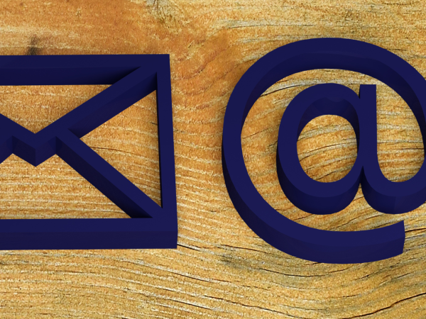A wooden background with 2 symbols the mail (letter) symbol and the email symbol (@)