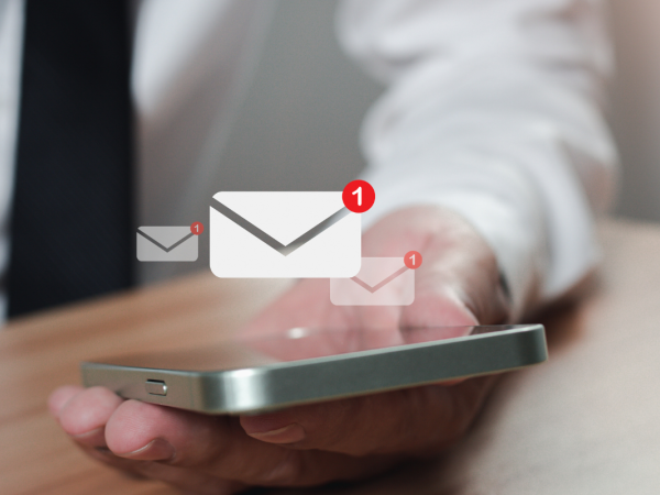 A person holding a smart phone with a message icon 