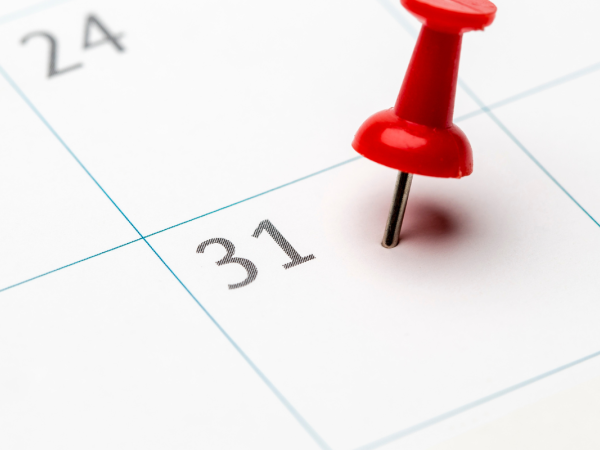 A calendar with a red pin pushed in the date box of the 31st A calendar with a red pin pushed in the date box of the 31st