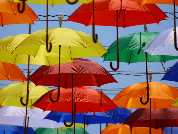 Lots of colourful umbrella's hanging from cords in the sky