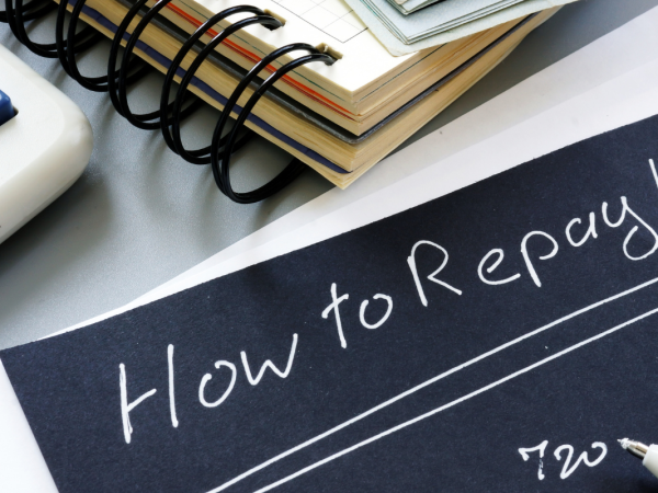 black paper with white writing saying 'HOW TO REPAY LOANS' black paper with white writing saying 'HOW TO REPAY LOANS'