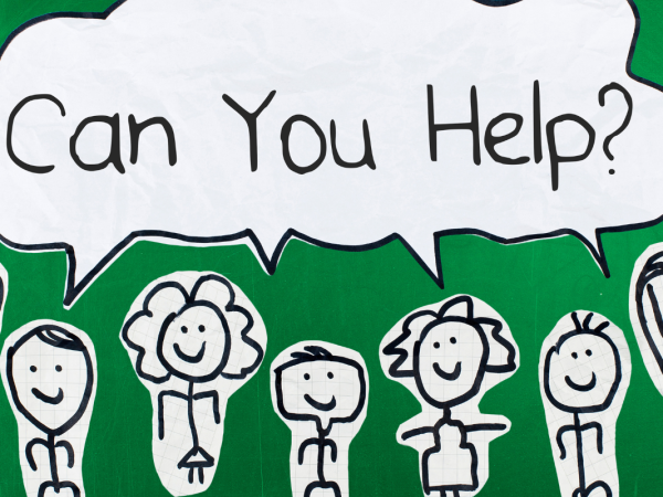 Stick people drawn on white paper, cut out and stuck on a green background with a speech bubble that reads 'CAN YOU HELP?' Stick people drawn on white paper, cut out and stuck on a green background with a speech bubble that reads 'CAN YOU HELP?'
