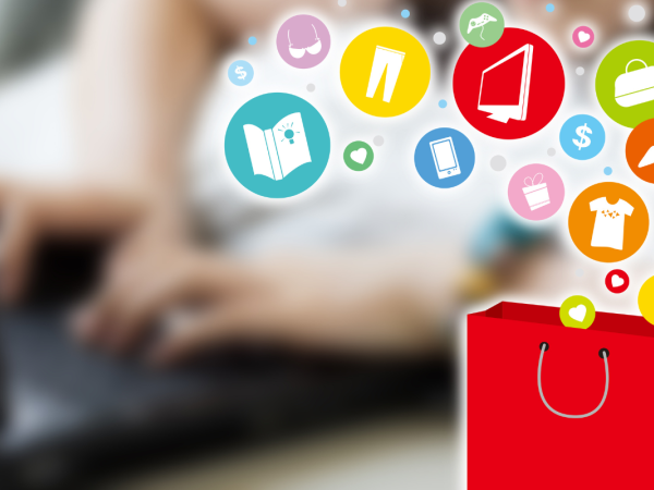 Icons of things you pay purchase online floating into a shopping bag, in the background a person can be seen typing on a laptop Icons of things you pay purchase online floating into a shopping bag, in the background a person can be seen typing on a laptop
