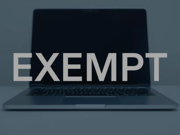 the word 'EXEMPT' in front of an open laptop 