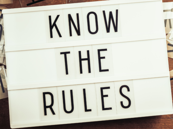 A light board with letter tiles on that make up the words 'KNOW THE RULES'