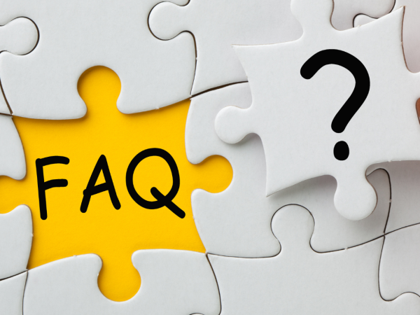 A white jigsaw with one piece left to insert, in the remaining space the letters 'FAQ' can be seen against the yellow surface, the final jigsaw piece has a question mark on it. 