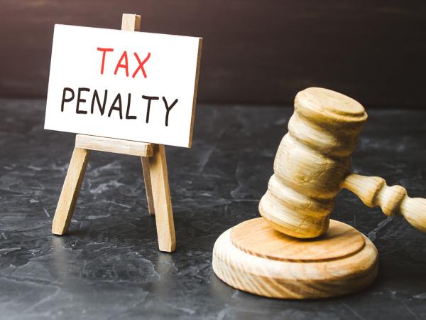 A hammer, gavel and a tiny canvas on a stand that reads 'TAX PENALTY' 