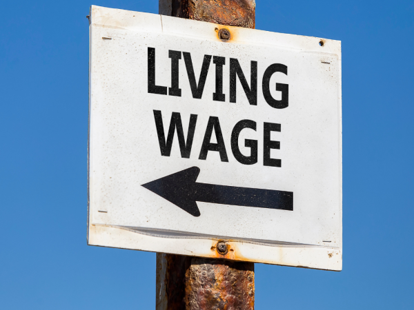 A sign post with the words 'LIVING WAGE' and an arrow 