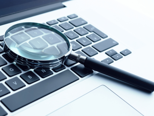 a laptop keyboard with a magnifying glass resting on top. 