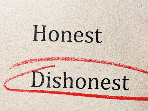 A piece of paper with 2 words typed on it 'HONEST' and 'DISHONEST' the word dishonest has been circled with red pencil.
