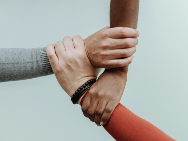 three hands supporting one another 