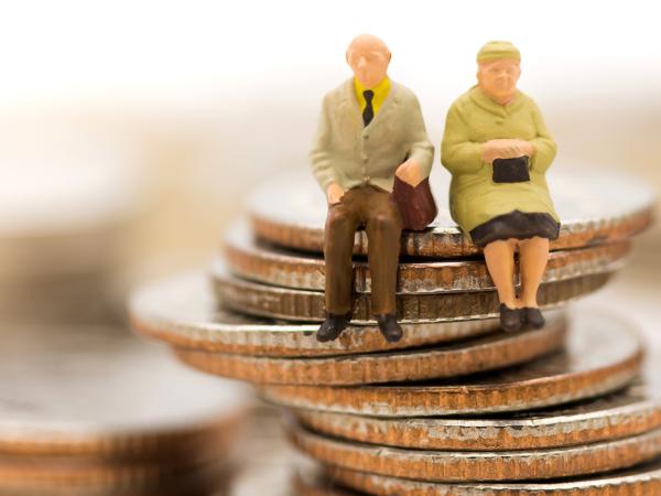 Image of models of pensioners sitting on a pile of coins