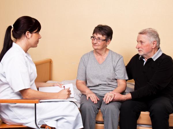Carer-helping-elderly-couple