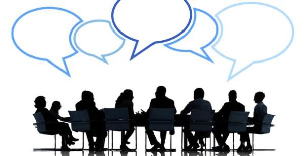 silhouette of people sat around a table with blue speech bubbles above their heads