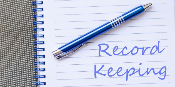 A pad of paper with a blue pen, written on the paper in blue ink are the words 'RECORD KEEPING' A pad of paper with a blue pen, written on the paper in blue ink are the words 'RECORD KEEPING'