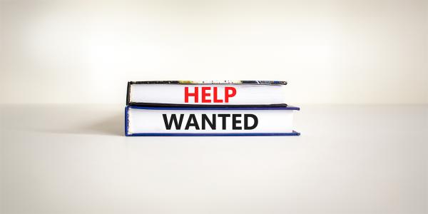 2 books against a neutral coloured background, on the side of the books the words 'HELP WANTED' is written in black and red. 2 books against a neutral coloured background, on the side of the books the words 'HELP WANTED' is written in black and red.