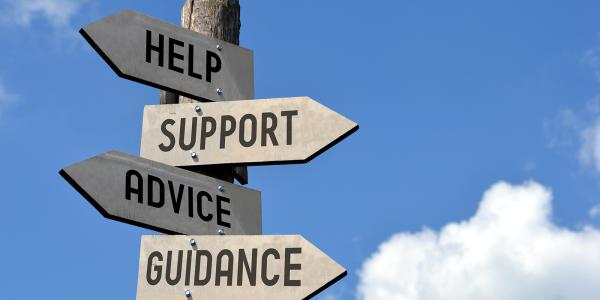 a blue sky with a wooden street sign, 4 arrows are nailed to the sign pointing in different directions saying 'HELP', 'SUPPORT', 'ADVICE', 'GUIDANCE'.