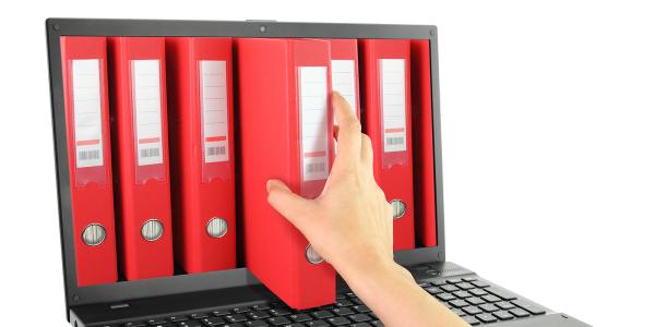 A laptop screen showing various red folders, a person is reaching into the screen to retrieve one of the files.
