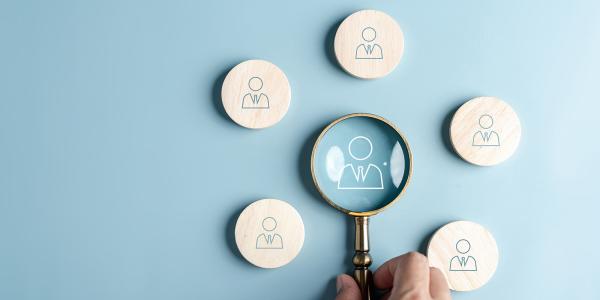 5 wooden circles showing a person wearing a shirt and tie, in the centre is a small magnifying glass - inside this is another person wearing a shirt and tie. 