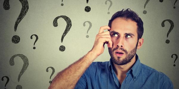 man scratching his temple confused, surrounded by question mark symbols 