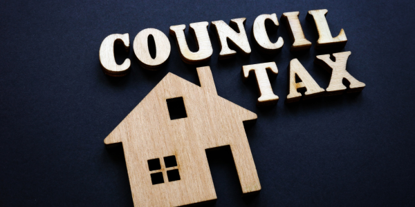 a house and the words 'council tax' carved from wood against a navy blue background