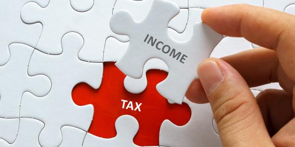 White Jigsaw on a red background, written on the final piece is 'INCOME' written on the red background where the final piece will sit is the word 'TAX' White Jigsaw on a red background, written on the final piece is 'INCOME' written on the red background where the final piece will sit is the word 'TAX'