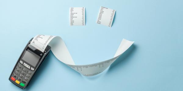 A till roll printing a long receipt and 2 smaller receipts arranged to look like a smiley face on a pale blue background