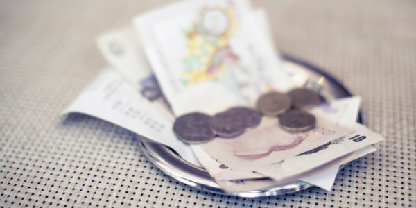 silver plate containing receipt, cash and coins. 